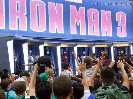 The Marvel booth decked out with all the Iron Man suits as attendees vie for some giveaways.